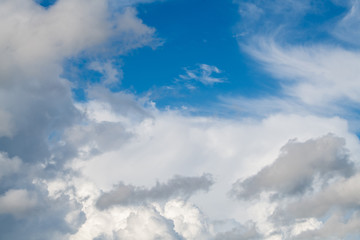 Multi-layered cumulus and feathery clouds in the blue sky
