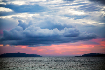 Obraz premium A pink sunset on a stormy sky on the Raja Ampat islands, Indonesia