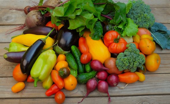 Many different colorful vegetables on a wooden background. Harvest and summer season concept.