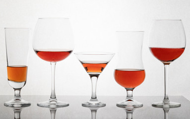 Glass glasses of different sizes with a drink on a white background.