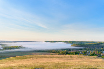 Fototapeta na wymiar sunrise, fog over the river panorama of the landscape in the early morning. thick fog is illuminated by the sun's rays in summer
