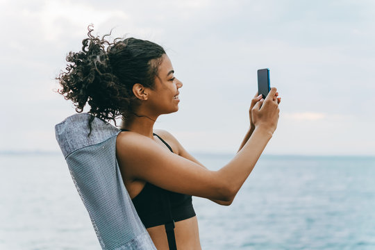 Image of smiling african american sportswoman taking selfie on cellphone