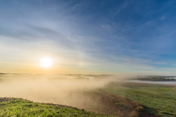 sunrise, fog over the river panorama of the landscape in the early morning. thick fog is illuminated by the sun's rays in summer