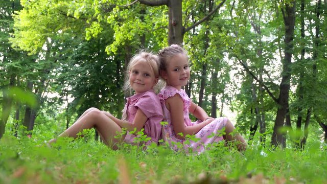 Two preschool girls on the grass in the park
