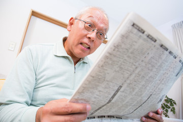 新聞を読むシニア男性