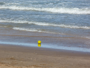 Obraz premium Yellow ball alone on the beach