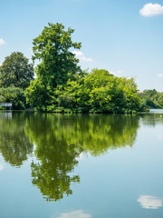 View of Mogosoaia lake located near Bucharest, Romania. Nature landscape with trees and the sky reflecting in the water of a lake.