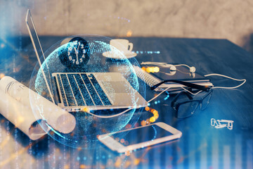 Double exposure of desktop with computer and world map hologram. International data network concept.