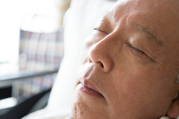 Obraz premium 介護ベッドで眠るシニア男性