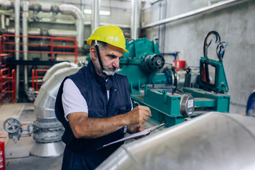 middle aged blue collar worker working in heat plant