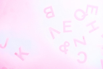 Silhouettes of alphabet letters on pink background. English letters stamp. Top view. Copy space for your creative design