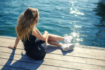 Woman in dress enjoys sea on the pier.