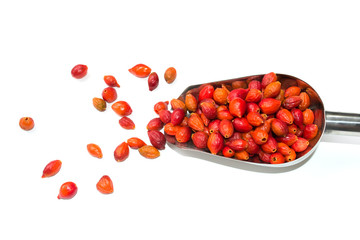 Fresh berries of wild rose in a metal scoop on a white background. Close-up