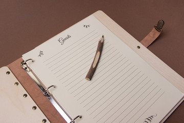 wooden guests book with pen on brown colored paper background. close up