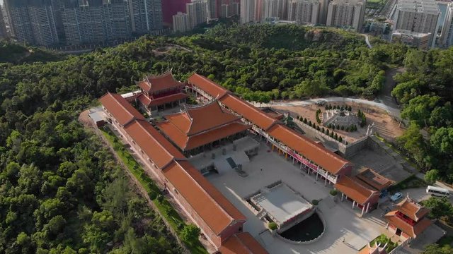Rotating and tilting aerial reveal of Macau cityscape from A-Ma Temple, Coloane