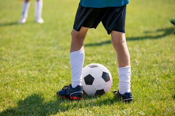 Football players feet close up. Sports training  on a grass field background. Boy in a sportswear....
