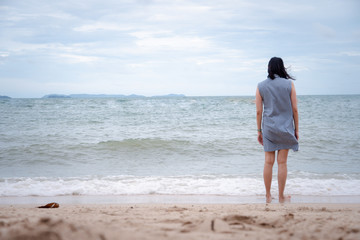 Asian woman walking alone on the beach. concept for holiday vacation and relaxing.