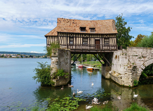 The Old mill (le vieux moulin) on the Vernon broken bridge on Seine river witrh swans in foreground- Vernon, Normandy, France