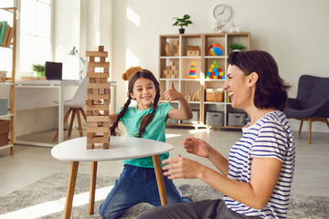 Mother and daughter play board games at home. Happy family.