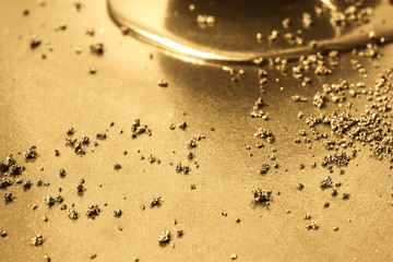 Liquid gold, gold dust on a gold background.