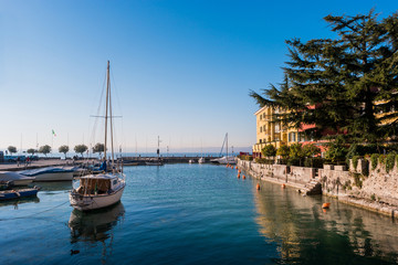 Fototapeta na wymiar Small tourist port with private boats on Garda Lake, Sirmione, Brescia, Italy