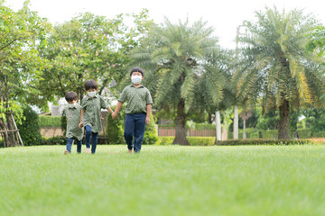 Naklejka premium 3 brothers are walking and playing in the garden in the evening..