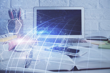 Double exposure of desktop with computer and world map hologram. International data network concept.