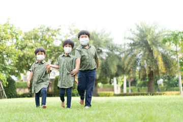 Obraz premium 3 brothers are walking and playing in the garden in the evening..