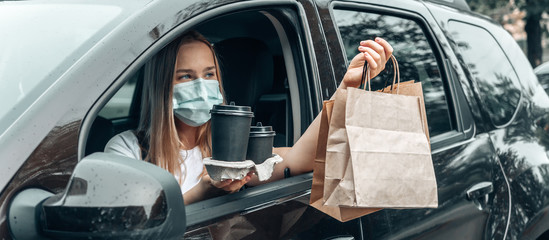 Contactless delivery. Girl Courier with food takeaway zero waste paper packaging delivers groceries. Concept takeaway take-out, carry-out  stay home