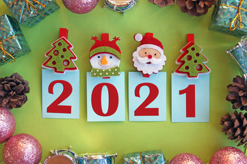 Year 2021 on a green background and symbols of the winter holiday.
