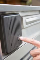 インターホンを押す男性の手元