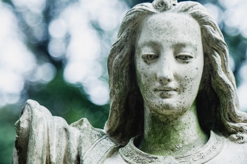 Death. Close up sad angel as symbol of pain, fear and end of life. Ancient stone statue. Horizontal...