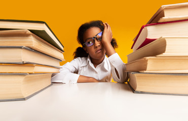 Overworked African Schoolgirl Sitting At Books Over Yellow Studio Background