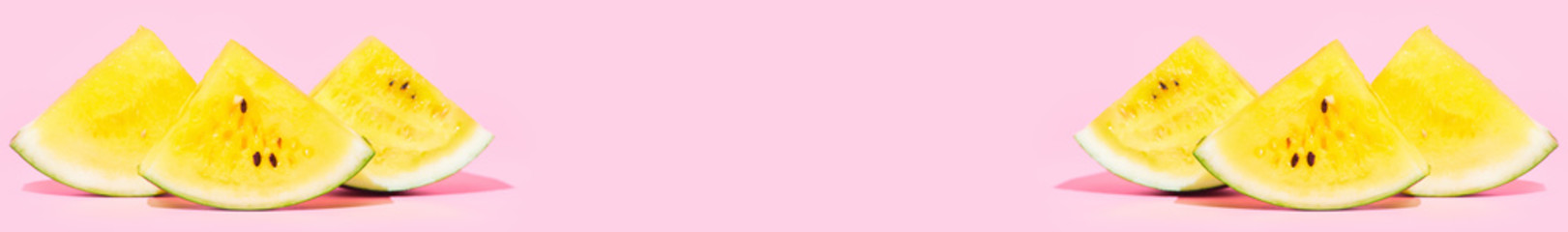 Banner ,slices of yellow watermelon on a pastel pink background, copy space
