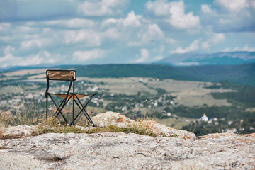 Fototapeta na wymiar Breathtaking mountains view. Adventure travel. Time to travel and travelling concept. Tourist chair on top of mountain