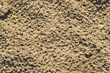 Yellow sand texture close up. Dirty sand with small stones.