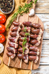 Raw shish kebab with chicken hearts on a wooden skewer. White background. Top view