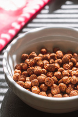 Chocolate balls cereal breakfast light through the blinds vertical orientation
