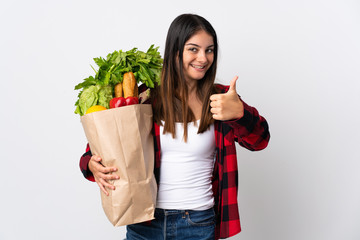 Young caucasian with vegetables isolated on white background with thumbs up because something good has happened