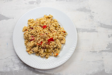 fresh vegetable salad with couscous on white plate