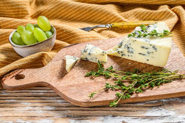 French Gorgonzola cheese with grapes. White wooden background. Top view