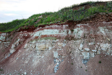 textures of various clay layers underground in  clay quarry after  geological study of  soil. colored layers of clay and stone in  section of  earth, different rock formations and soil layers.