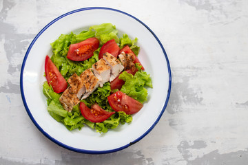fresh salad with grilled chicken and sauce on the plate