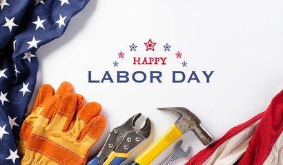 Happy Labor day concept. American flag with different construction tools on white background, with copy space for text.