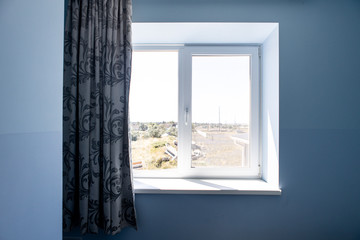 Fototapeta premium window to the street, sill and curtain, view from the room