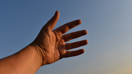 Frau mittleren Alters, Handfläche vor blauem Himmel, Hand von innen als Handzeichen