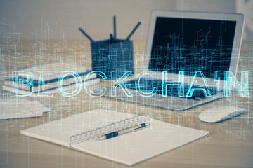 Multi exposure of blockchain theme hologram and table with computer background. Concept of bitcoin crypto currency.