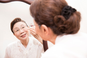 Obraz premium 化粧をするシニア女性