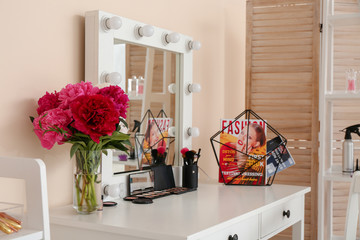 Table with makeup cosmetics and accessories in dressing room