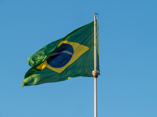 Brazil flag fluttering in the wind. In the center of the flag with the words "order and progress"